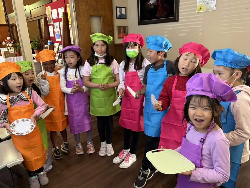 Mandarin summer camp students in chef aprons for a cooking theme week