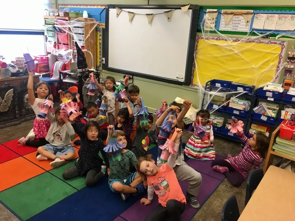 Young students sitting on the classroom rug during an Everyday Mandarin after-school class at Francis Scott Key Elementary