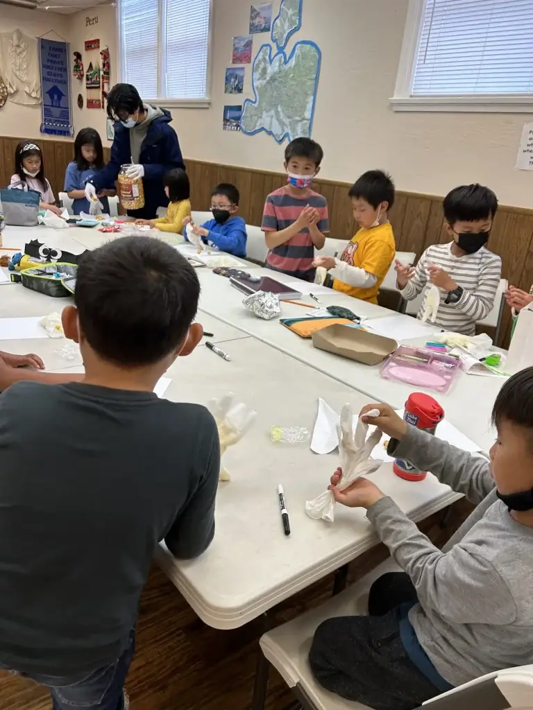 Elementary students working on Mandarin activities at tables during an Everyday Mandarin after-school class